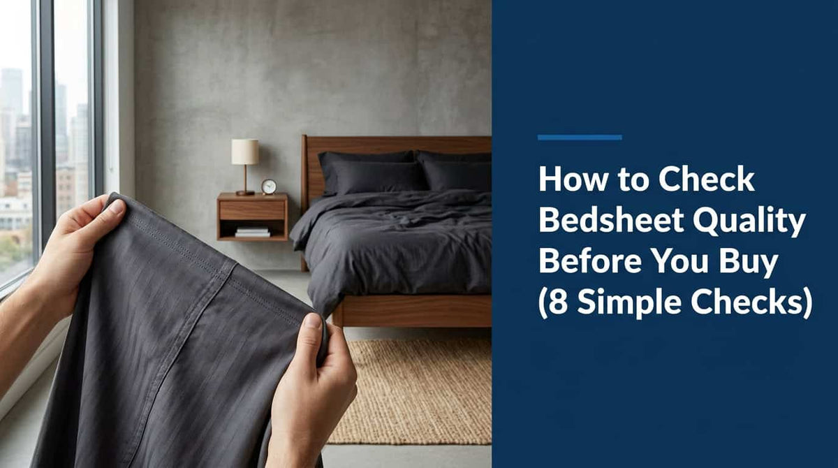 Hand feeling the fabric of a dark grey bedsheet to check its quality