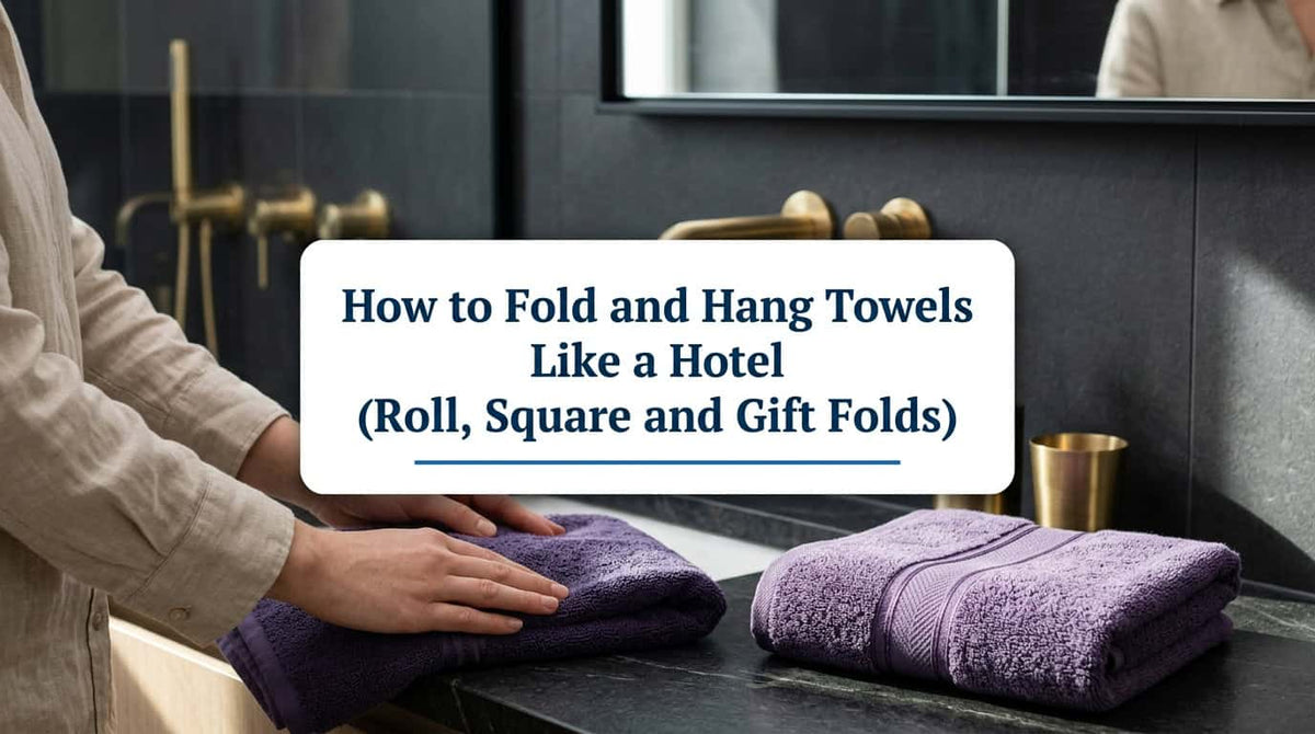 Hands folding a purple towel next to neatly folded towels