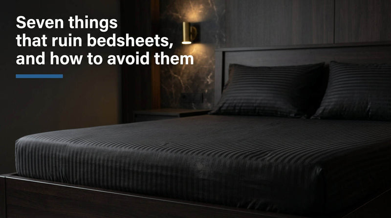 Black cotton fitted bedsheet and pillow covers on a neatly made bed