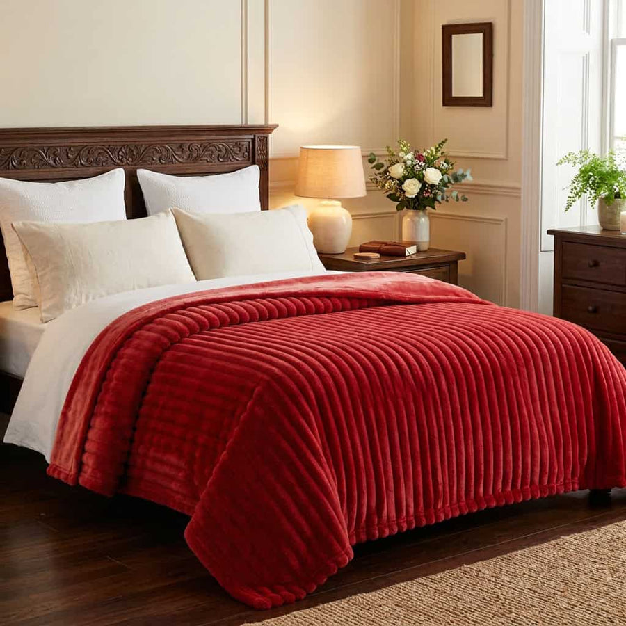 Red ribbed fleece AC blanket spread over a double bed