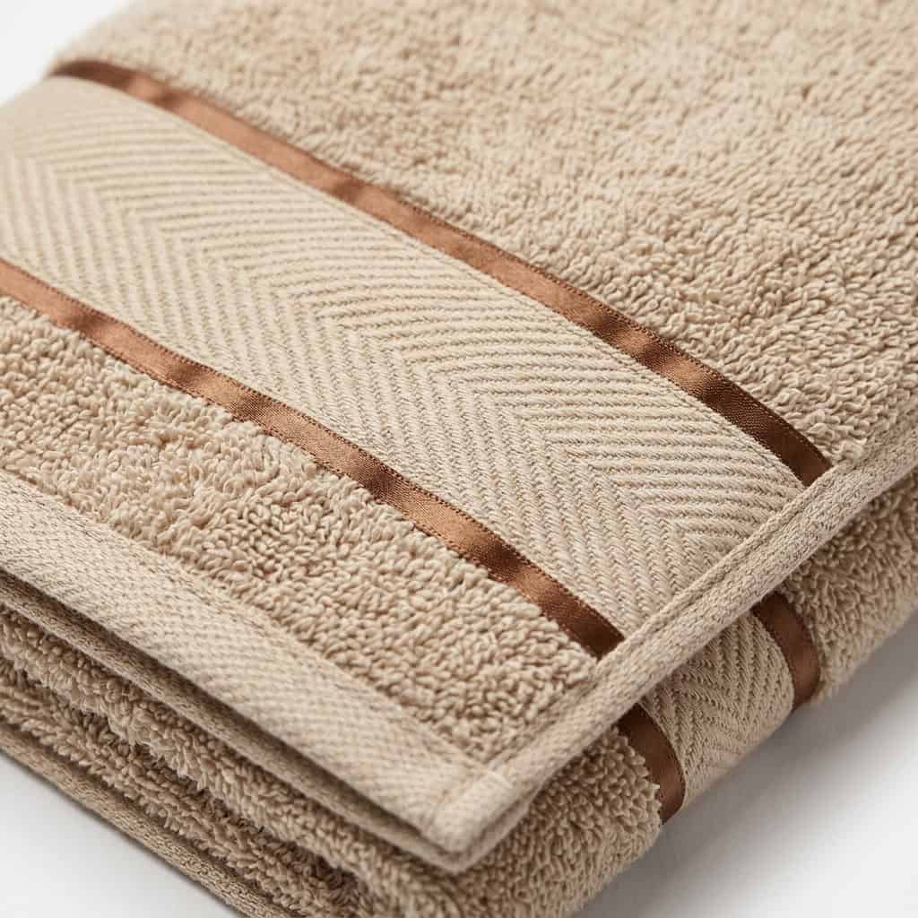 Close-up of beige cotton towel loops and woven border