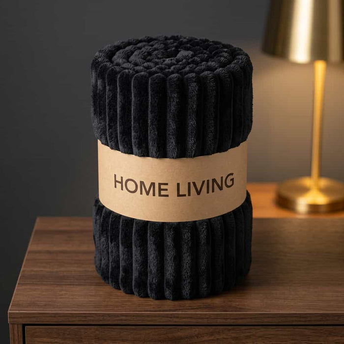 Rolled black ribbed fleece AC blanket with a Home Living label