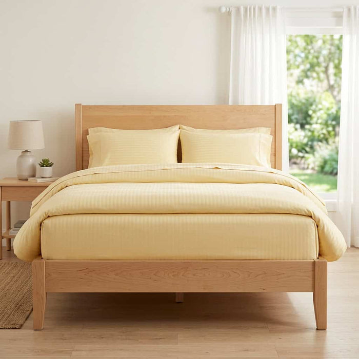 Butter yellow cotton fitted bedsheet with 2 pillow covers on a king size bed