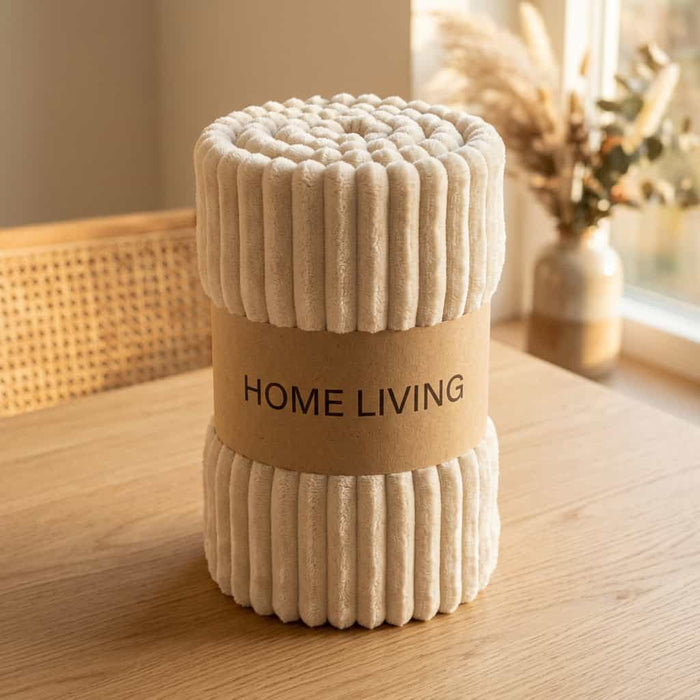 Rolled cream ribbed fleece AC blanket with a Home Living label