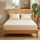 Cream cotton fitted bedsheet with 2 pillow covers on a king size bed