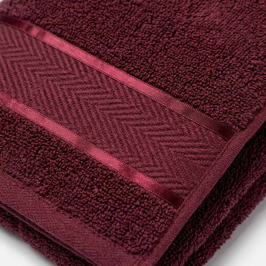 Close-up of maroon cotton towel loops and woven border