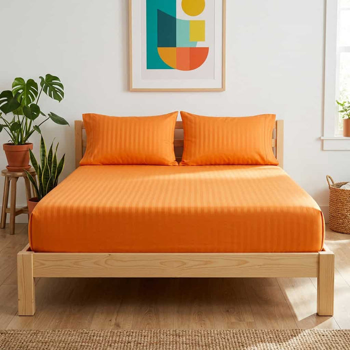 Orange cotton fitted bedsheet with 2 pillow covers on a king size bed