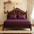 Plum cotton fitted bedsheet with 2 pillow covers on a king size bed