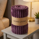 Rolled purple ribbed fleece AC blanket with a Home Living label