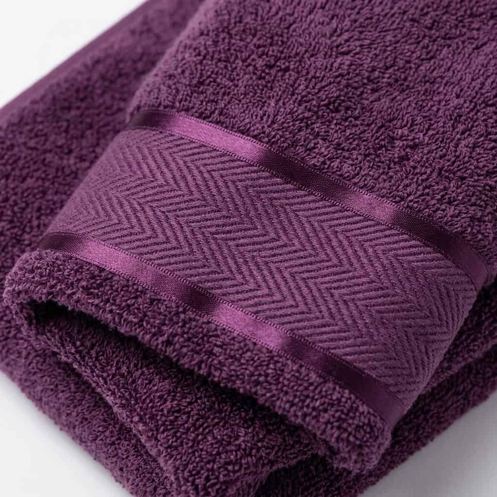Close-up of purple cotton towel loops and woven border