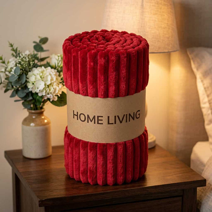 Rolled red ribbed fleece AC blanket with a Home Living label